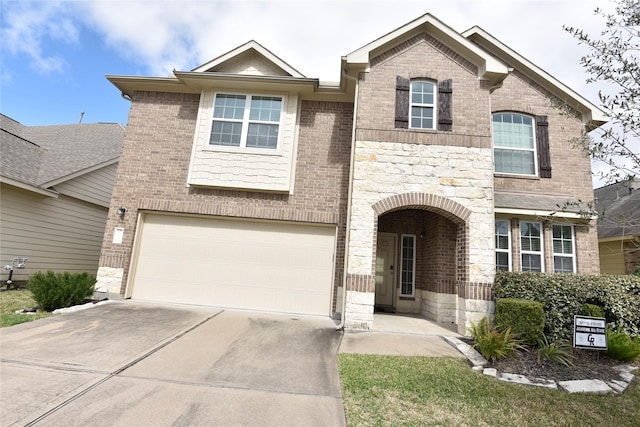 view of front of property with an attached garage, stone siding, concrete driveway, and brick siding