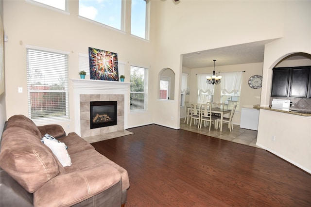 living room with dark wood-style floors, a notable chandelier, and a fireplace