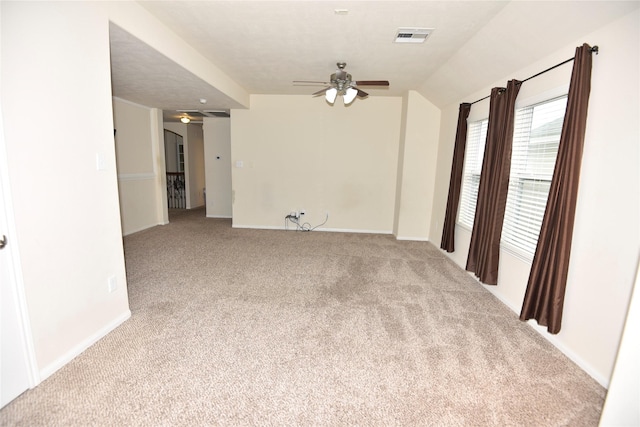 carpeted spare room featuring visible vents, ceiling fan, and baseboards