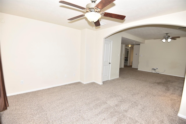 spare room featuring a ceiling fan, baseboards, arched walkways, and carpet flooring