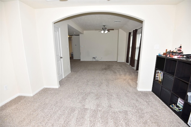 unfurnished room with arched walkways, carpet, visible vents, ceiling fan, and baseboards