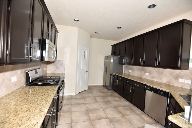 kitchen with light tile patterned floors, visible vents, appliances with stainless steel finishes, backsplash, and light stone countertops