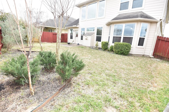 back of property with a yard and fence