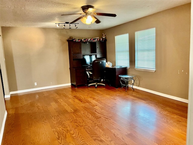 office area with ceiling fan, a textured ceiling, baseboards, and wood finished floors