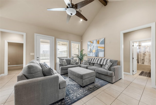 living area with light tile patterned floors, baseboards, a ceiling fan, beamed ceiling, and high vaulted ceiling