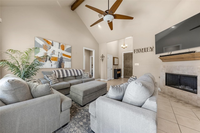 living area featuring high vaulted ceiling, tile patterned flooring, a tile fireplace, ceiling fan with notable chandelier, and beamed ceiling