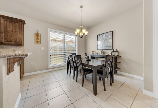 dining room featuring light tile patterned flooring, a notable chandelier, and baseboards