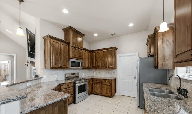 kitchen featuring visible vents, decorative backsplash, light stone counters, appliances with stainless steel finishes, and a sink