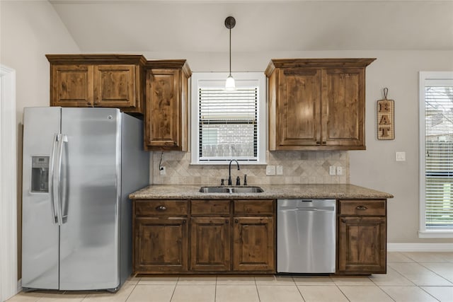 kitchen featuring a healthy amount of sunlight, backsplash, stainless steel appliances, and a sink