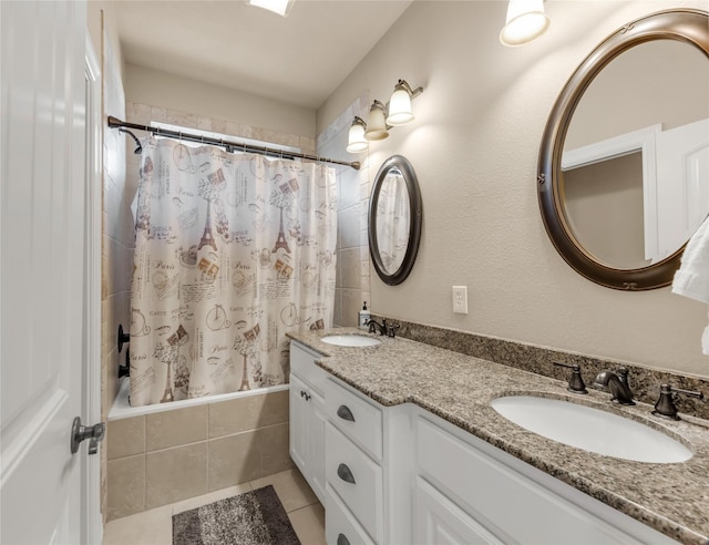 bathroom featuring tiled shower / bath, double vanity, a sink, and tile patterned floors