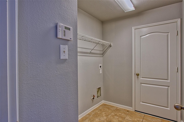 laundry room with laundry area, light tile patterned floors, baseboards, gas dryer hookup, and hookup for an electric dryer