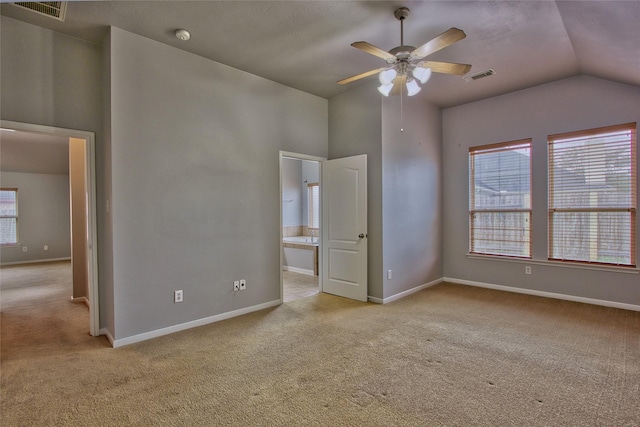 unfurnished bedroom with light colored carpet, visible vents, ensuite bath, and baseboards