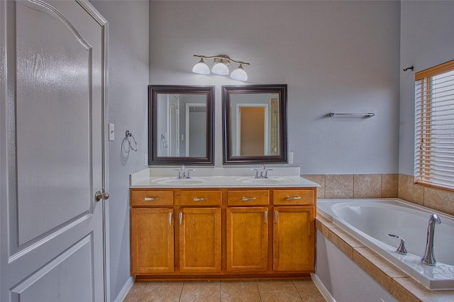 bathroom with double vanity, a garden tub, tile patterned flooring, and a sink