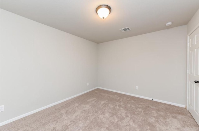 unfurnished room featuring carpet, visible vents, and baseboards