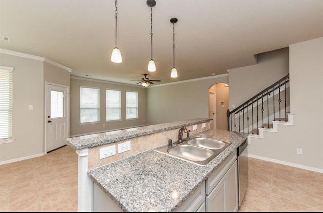 kitchen featuring arched walkways, dishwasher, crown molding, pendant lighting, and a sink