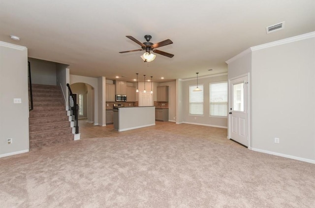 unfurnished living room featuring arched walkways, crown molding, light colored carpet, ceiling fan, and stairs