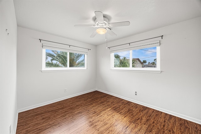 unfurnished room with baseboards, wood finished floors, and a ceiling fan