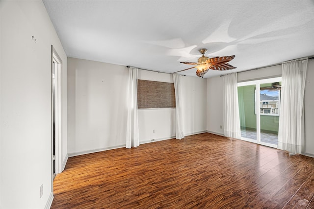 empty room featuring baseboards, a textured ceiling, ceiling fan, and wood finished floors