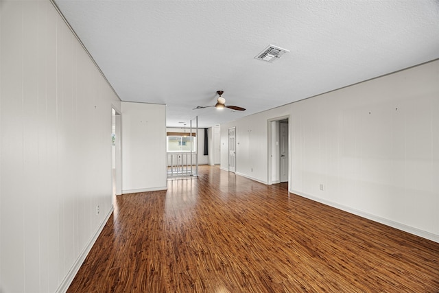 unfurnished room with ceiling fan, visible vents, a textured ceiling, and wood finished floors