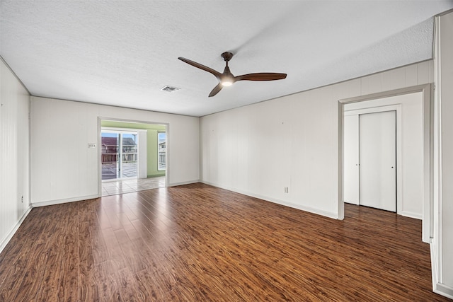 unfurnished room featuring visible vents, a textured ceiling, wood finished floors, baseboards, and ceiling fan