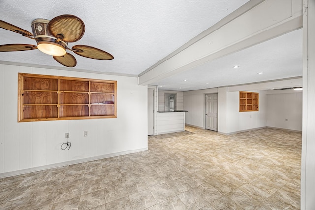 unfurnished living room with baseboards, a textured ceiling, and a ceiling fan