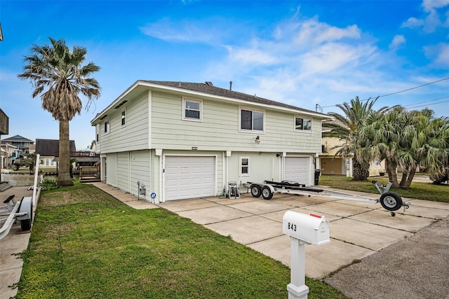 view of front of house with a garage, a front yard, and driveway