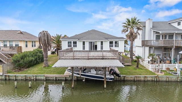 rear view of house featuring a lawn and a deck with water view