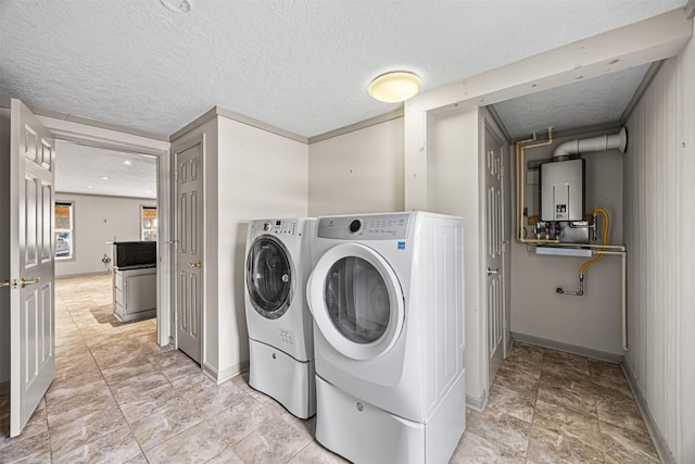 washroom featuring washing machine and clothes dryer, a textured ceiling, tankless water heater, and baseboards