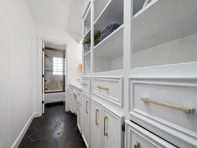 full bath with baseboards, shower / bath combination with glass door, vanity, and tile patterned flooring