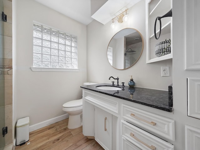 full bathroom with walk in shower, baseboards, toilet, wood finished floors, and vanity