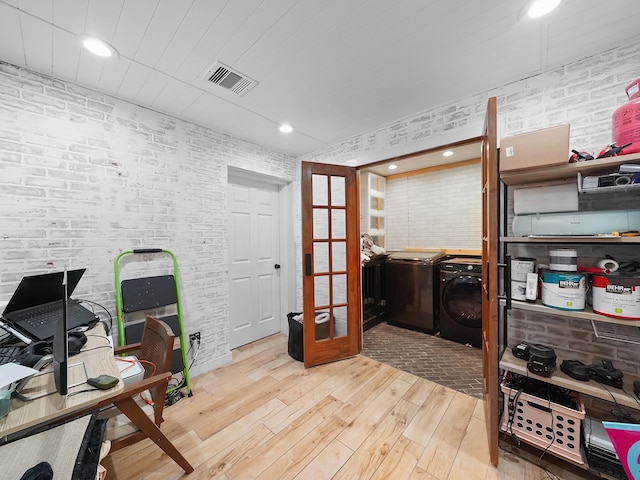 office space with washer and clothes dryer, visible vents, brick wall, and wood-type flooring