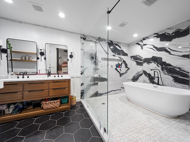 full bath with vanity, a freestanding tub, visible vents, and a marble finish shower