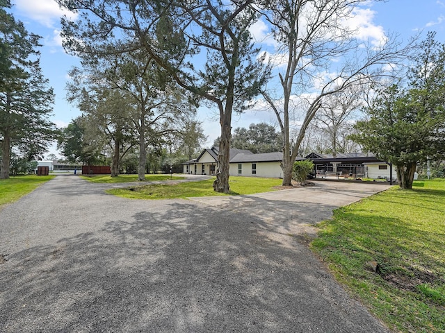 view of front of house with aphalt driveway and a front yard