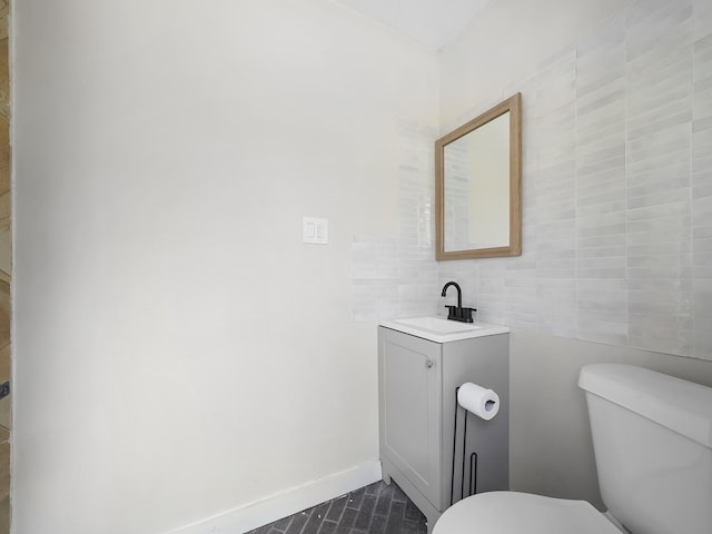 bathroom with vanity, toilet, and baseboards