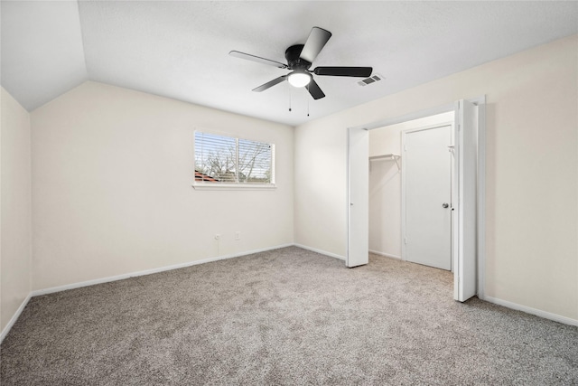 unfurnished bedroom featuring a ceiling fan, baseboards, visible vents, lofted ceiling, and carpet flooring