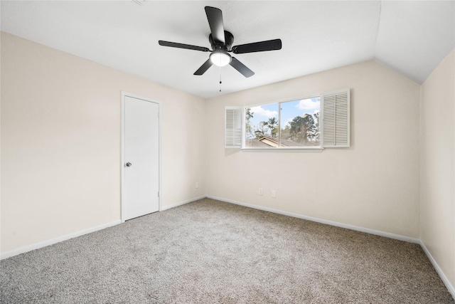 spare room featuring vaulted ceiling, carpet, baseboards, and ceiling fan