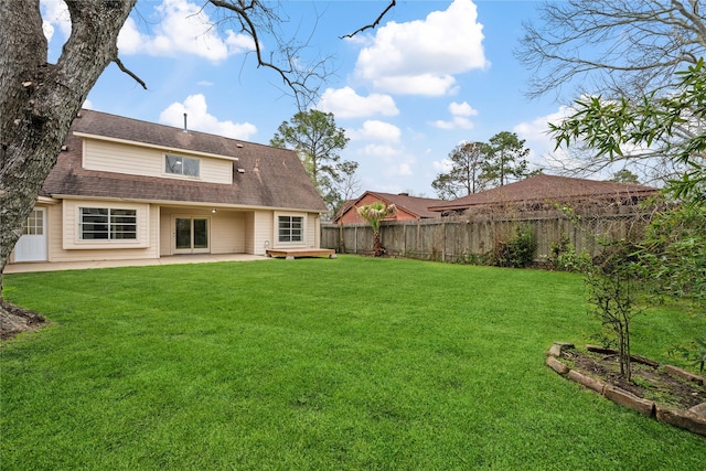 back of property with a patio area, a lawn, a fenced backyard, and a shingled roof