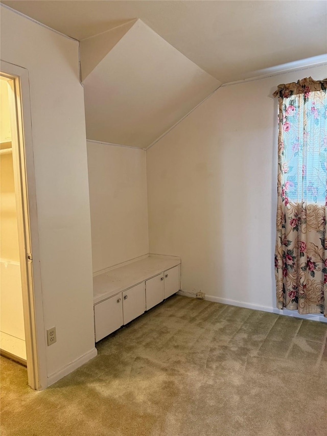 bonus room featuring lofted ceiling, baseboards, and light colored carpet