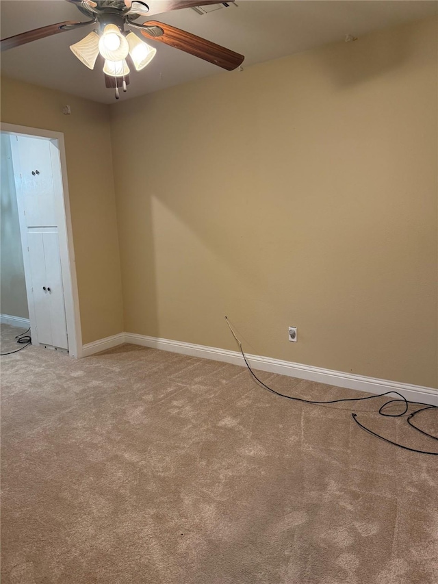 empty room with visible vents, baseboards, ceiling fan, and carpet flooring