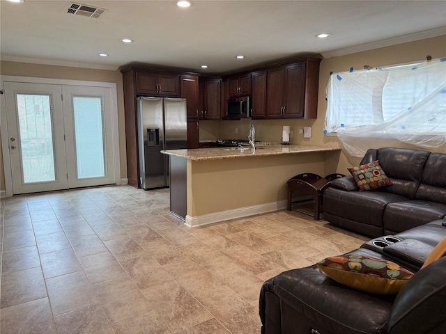 kitchen featuring dark brown cabinetry, a peninsula, visible vents, open floor plan, and appliances with stainless steel finishes