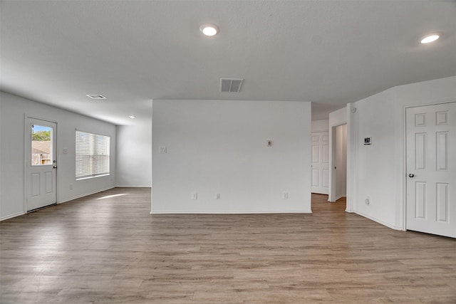 spare room with baseboards, light wood-style flooring, visible vents, and recessed lighting