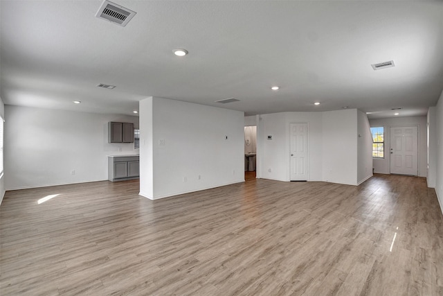 unfurnished living room featuring light wood-type flooring, visible vents, and recessed lighting