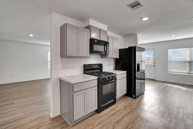 kitchen with black appliances, visible vents, gray cabinets, and light countertops