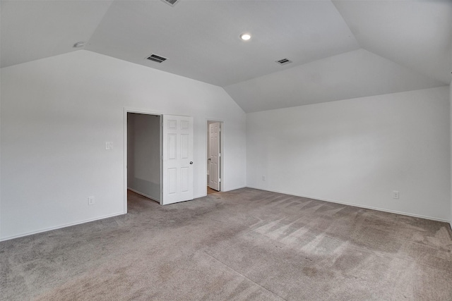 interior space featuring lofted ceiling, carpet floors, and visible vents