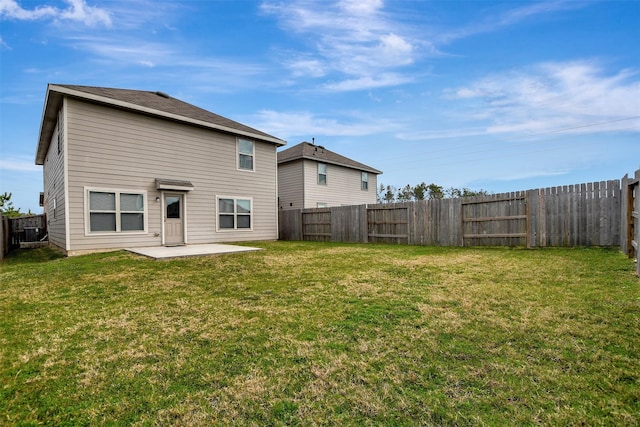 rear view of house featuring a fenced backyard, a lawn, and a patio