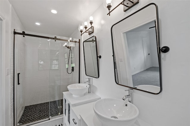 full bathroom featuring double vanity, a stall shower, a sink, and recessed lighting