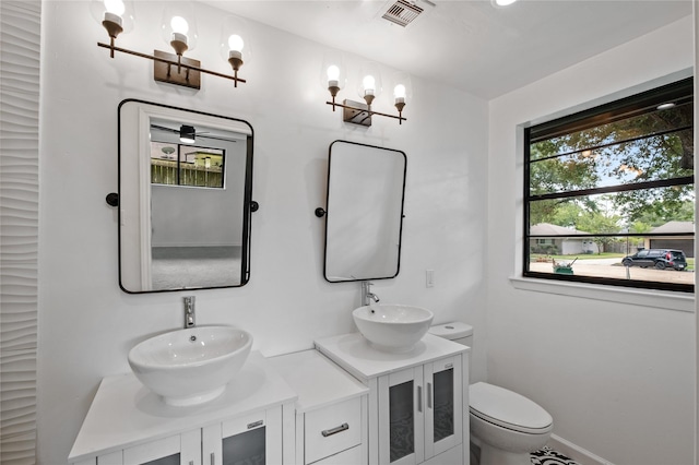 full bath with toilet, a sink, visible vents, and an inviting chandelier