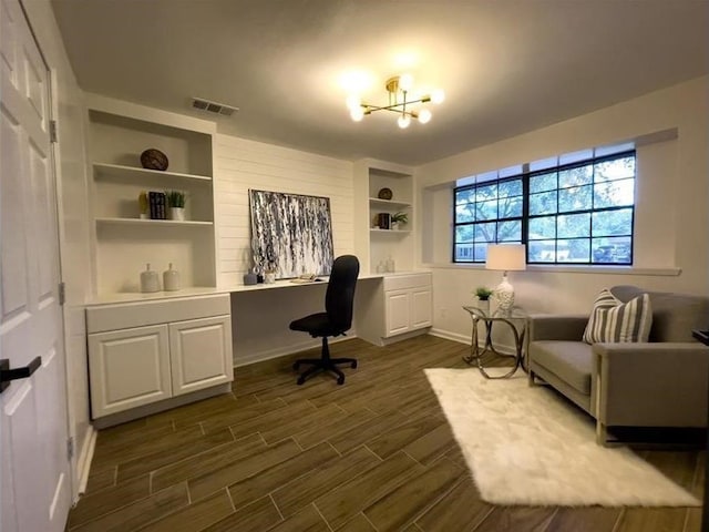 office area featuring visible vents, baseboards, built in features, wood tiled floor, and built in desk