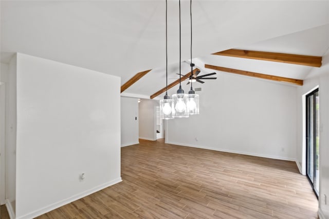 unfurnished living room featuring lofted ceiling with beams, wood finished floors, and baseboards