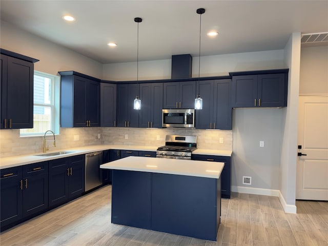 kitchen featuring blue cabinetry, stainless steel appliances, light countertops, visible vents, and a sink